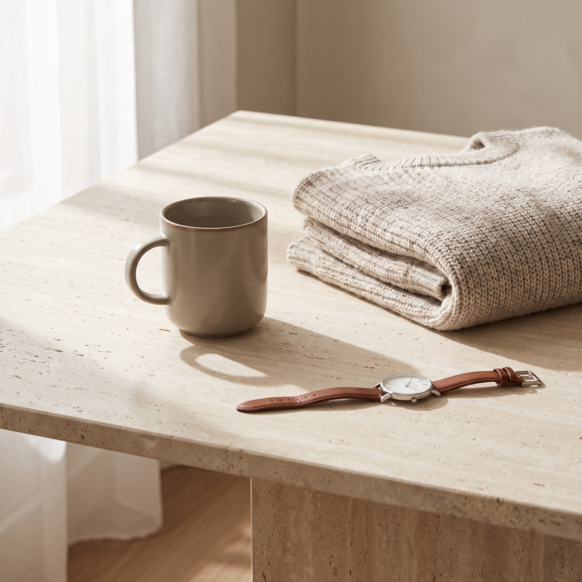 Stoneware mok met een gebreide trui en horloge op travertijn